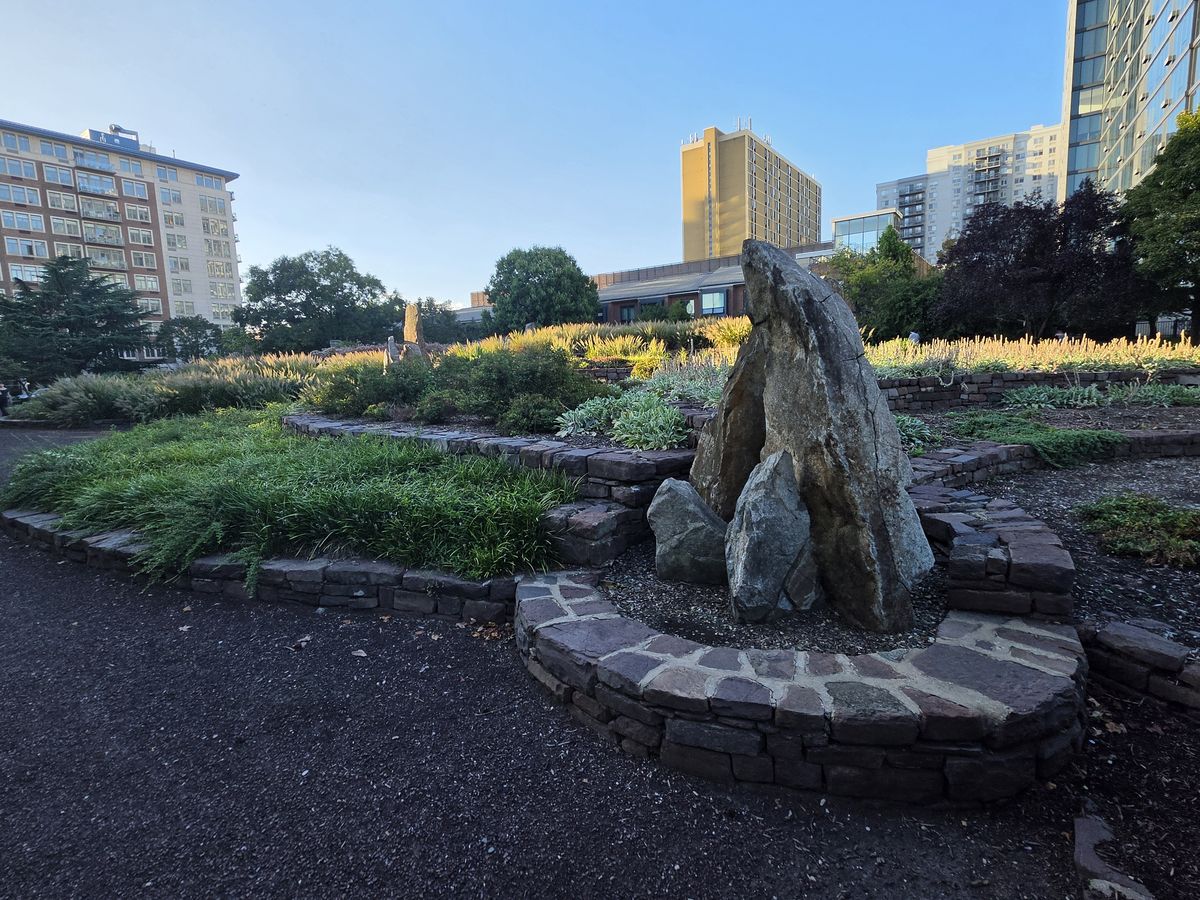 The standing rock structure at the center of the park, ringed by a low stone circle.